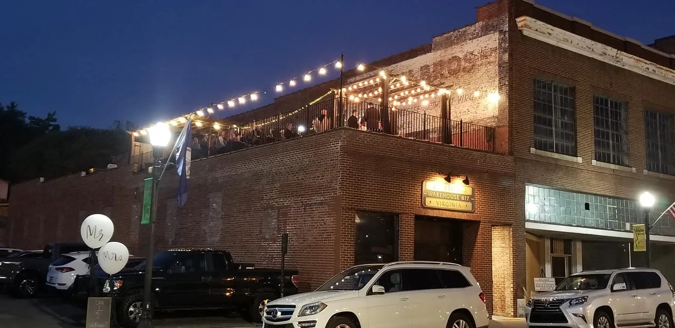 Warehouse 817 exterior at night with rooftop string lights and guests