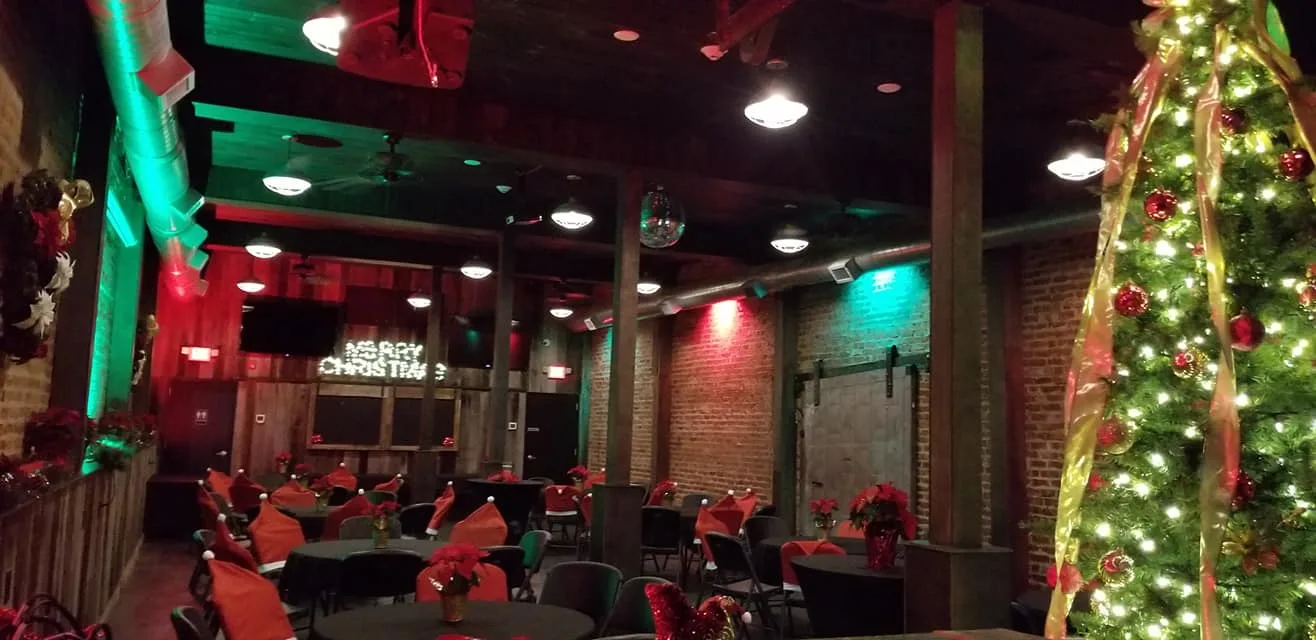 Event space decorated for the holidays with a Christmas tree and poinsettias