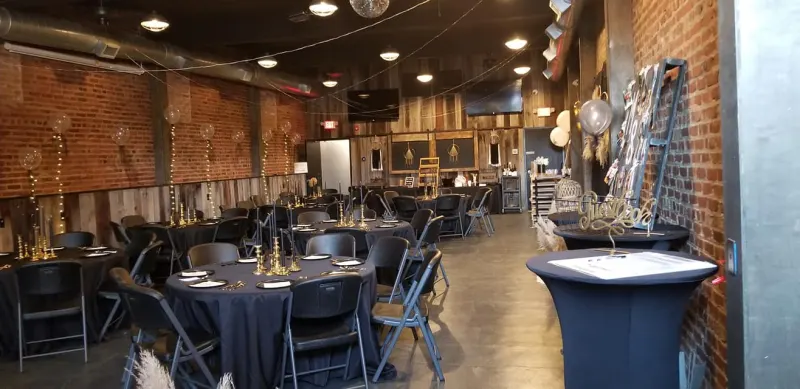 Reception with black linens, gold candlesticks, and string lights
