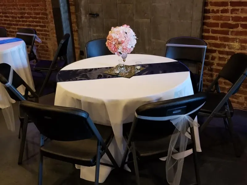 Reception table with white linens and a navy runner
