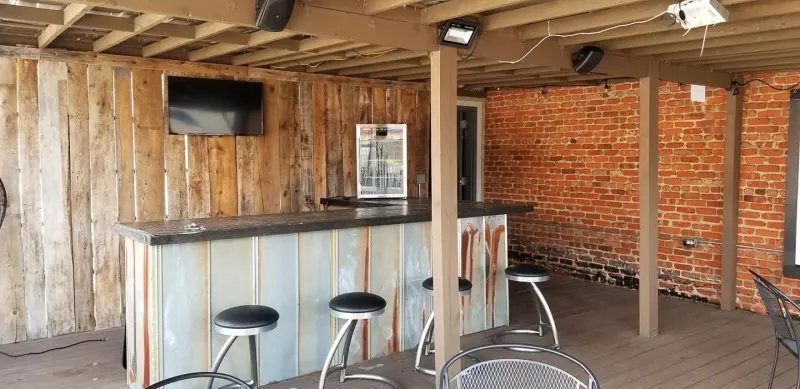 Rooftop bar with barstools and a mounted TV
