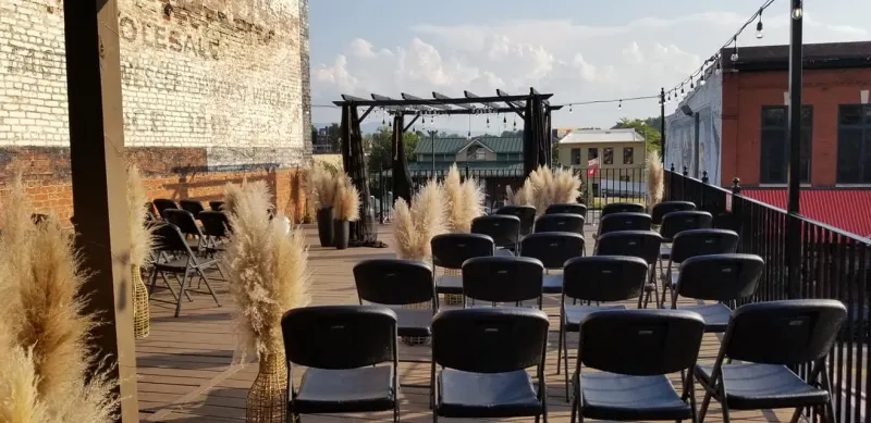 Rooftop ceremony seating with pampas grass and string lights