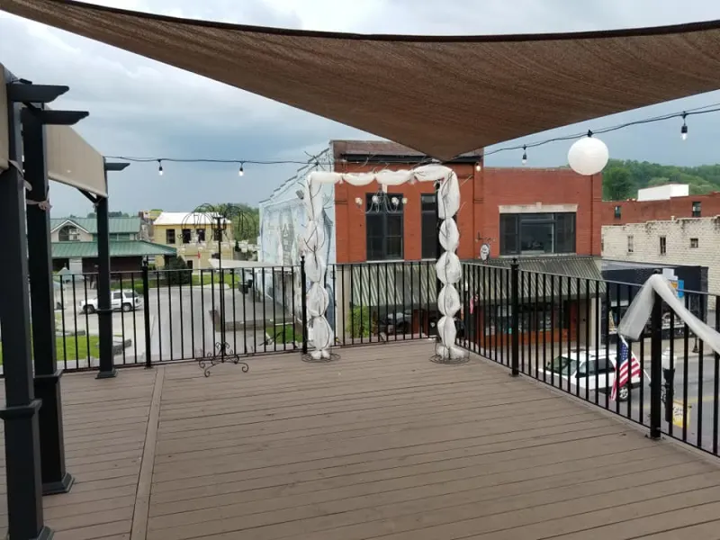 Rooftop deck with a floral arch and shade sail