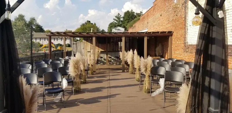 Rooftop ceremony aisle lined with pampas grass at sunset