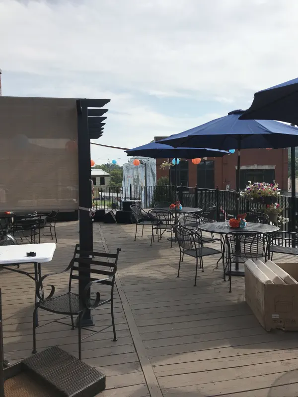 Rooftop patio with bistro tables and blue umbrellas