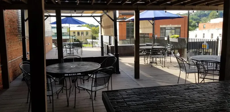 Covered rooftop patio with cafe tables