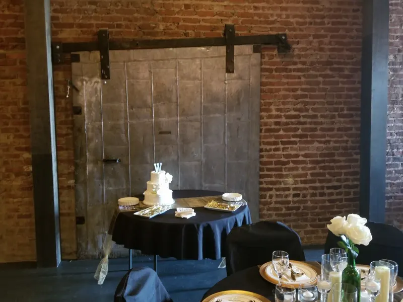Wedding cake table in front of the antique sliding barn door