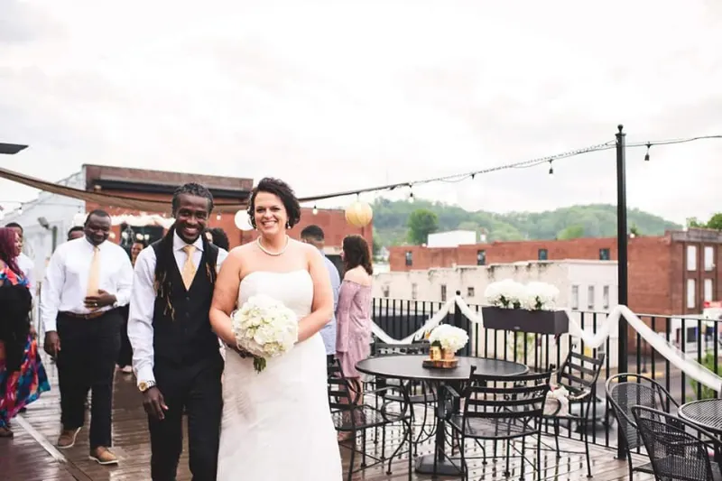 Newlyweds walking across the rooftop deck